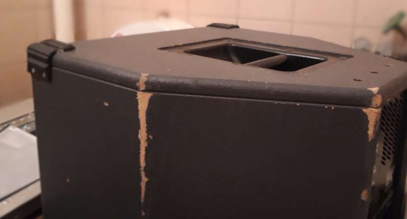 Foto von einem Lautsprecher in einer Klokabine, an einigen Stellen ist die Farbe weg